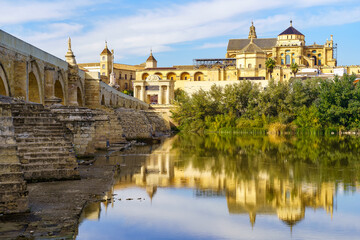 Cordoba mosque with reflections in the Guadalquivir river and the city's Roman bridge.