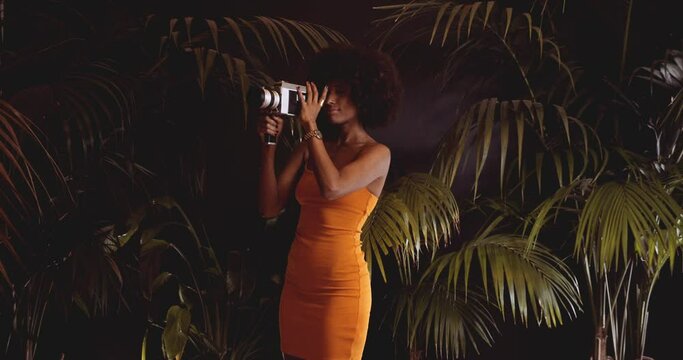 Woman With Afro Hair In Orange Dress Using Vintage 8Mm Camera