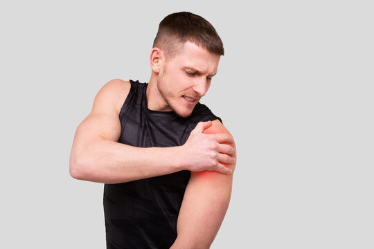 Sport man Holding Shoulder. Man Having Injury. Sport man Shoulder injury. Red Spot on Hurt Part.