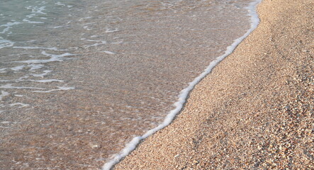 Beautiful seascape with beautiful sea waves and sea foam on shore with sea water on beach by sea