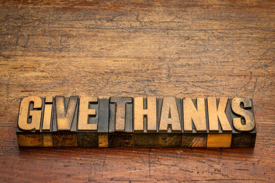 Give thanks word abstract in vintage letterpress wood type on rustic, weathered wood, Thanksgiving and fall holidays theme.
