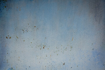 A sheet of grunge metal painted blue. Faded and weathered background.