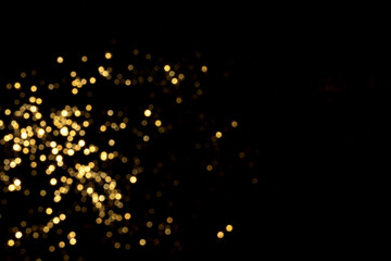 Golden blurred bokeh lights on black background. Glitter sparkle stars for celebrate. Overlay for your design