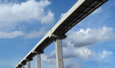 A large stanchion from a high angle of the rail system of the electric train with the background of the sky.