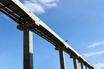 A large stanchion from a high angle of the rail system of the electric train with the background of the sky.
