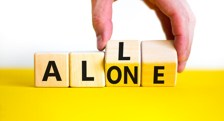 All or alone and support symbol. Businessman turns the wooden cube and changes the word alone to all. Beautiful white background. Business and all or alone and support concept. Copy space.