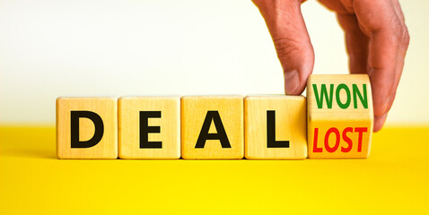 Deal lost or won symbol. Businessman turns a wooden cube and changes words deal lost to deal won. Beautiful yellow table, white background, copy space. Business and deal lost or won concept.