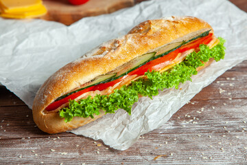 Breakfast of Fresh croissant with ham, cheese and salad leaf on white wooden background.