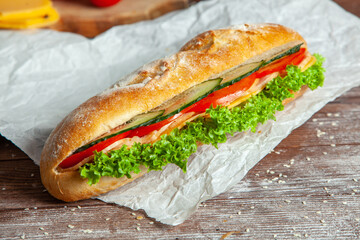 Breakfast of Fresh croissant with ham, cheese and salad leaf on white wooden background.