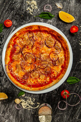 Fresh pizza with a ton on wood background