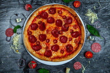 Pizza with salami and sausages on wood background.