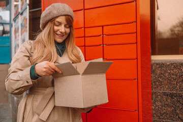 Pickup parcel. Woman hands with boxes at outdoor automated parcel machine. Mail delivery and post service concept.
