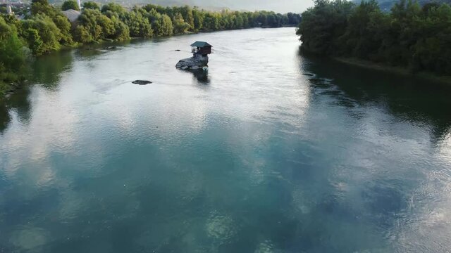 Small wooden cabin on a rock in the middle of river Drina, Serbia.	
