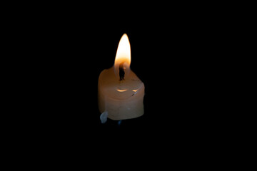 Light candle burning brightly in the black background