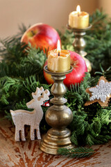 Traditional Christmas decoration with apples, cinnamon sticks and candles.