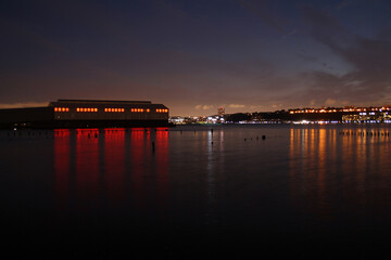 Fototapeta premium An industrial night shot with the pier and the light behind the river