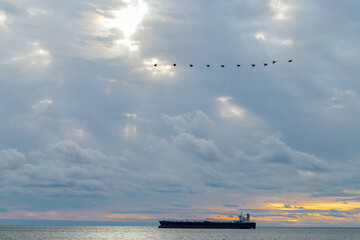 Fototapeta na wymiar the ship sails on the sea against the backdrop of a beautiful cloudy sky.