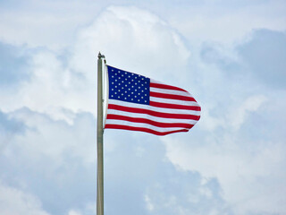 Fototapeta premium American flag waving against the blue sky in USA