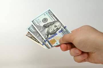 A man's hand holds American dollars in his hands, money transfer, payment with money