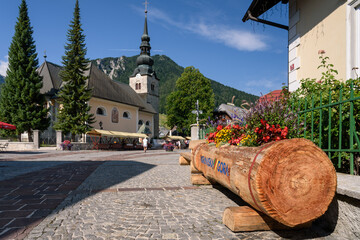 Flowering street in the town of Kranjska Gora with the Church of the Assumption of the Virgin Mary,...