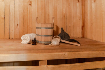 Traditional old Russian bathhouse SPA Concept. Interior details Finnish sauna steam room with traditional sauna accessories set basin towel aroma oil scoop felt. Relax country village bath concept