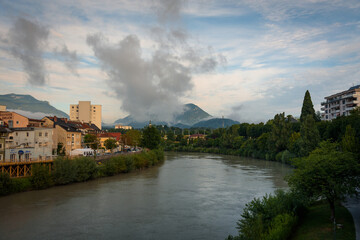 Fototapeta na wymiar View of the riverside of Drau river with low clouds at sunrise, Villach, Austria