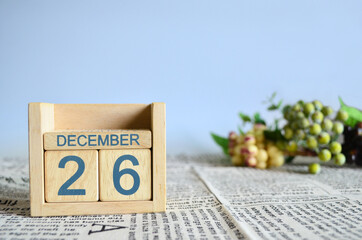 December 26, Calendar cover design with number cube with fruit on newspaper fabric and blue...