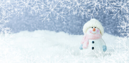 Christmas background. Happy snowman standing in a winter Christmas landscape. Merry christmas and happy new year greeting card. Funny snowman in a hat on a snowy background. Banner.