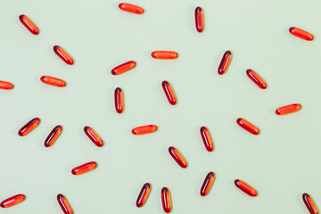 Red capsule pills on green background