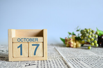 October 17, Calendar cover design with number cube with fruit on newspaper fabric and blue background.