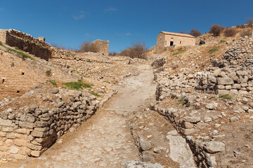 Ruins of the ancient Greek city of Acrocorinth with a stone road, walls and towers, Corinth, Greece