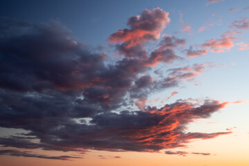 Naklejka na ściany i meble Dramatic cloudscape with colorful clouds at sunrise
