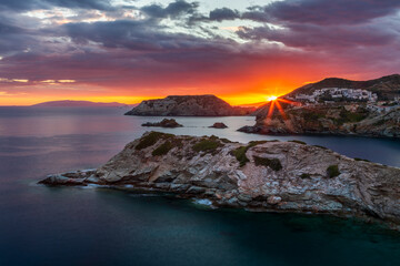 Colorful sunrise over the rocky cliffs of the north coast of Crete with the sun in the frame