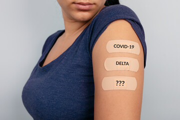 woman showing many plasters on shoulder after coronavirus vaccine, new stamps concept, mutation...