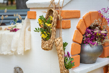 Russian stove, with a pan and flowers. Bast shoes hang on the stove.
