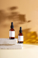 Face and body skin care products in a glass bottle with a pipette on a concrete podium. Cosmetics for women with natural ingredients. Copy space, layout