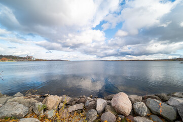 Barrie waterfront centennial park  lakeshore  path with green grass and fall colour trees   blue sky with broken clouds 