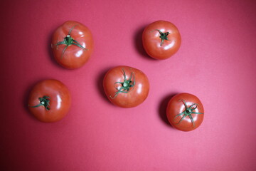 Ripe red fresh tomatos on red background