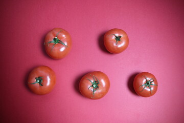 Ripe red fresh tomatos on red background with copy space
