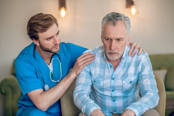 Experienced geriatric physician supporting an upset patient