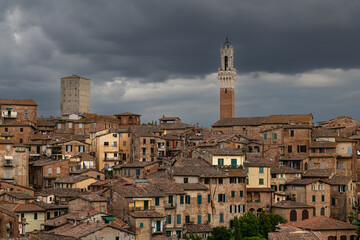 Fototapeta na wymiar Panoramic View over Siena with Torre del Mangia in Evening light with dramatic Sky, Siena, italy