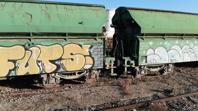 modelo subida en vag&oacute;n de tren de mercanc&iacute;as antiguo mostrando moda de ropa de temporada