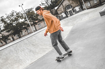 Guy in cap riding skateboard in park