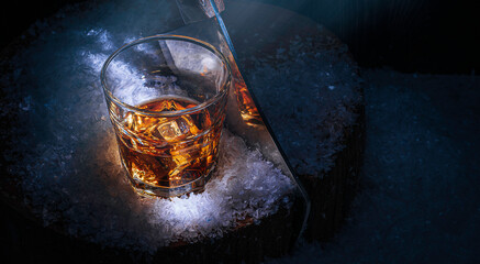 a glass of whiskey in the snow. concept of a warming drink on a cold winter evening.