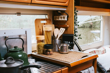 cozy kitchen interior in the trailer of mobile home or recreational vehicle, concept of family local travel in native country on caravan or camper van and camping life © klavdiyav