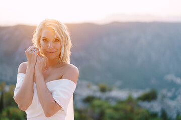 Fototapeta na wymiar Bride in a white dress on a background of mountains. Portrait