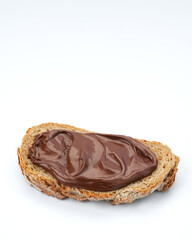 Slice of whole wheat toast with healthy chocolate hazelnut spread, on white background, space for text.