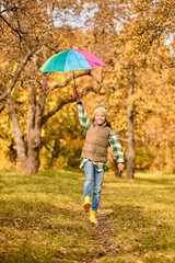 A girl with a bright umbrella in an autumn park