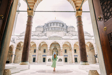 A young girl in a headscarf goes to a Suleymaniye Mosque mosque in Istanbul. Summer vacation,...