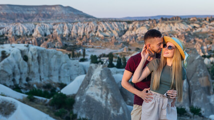 Fototapeta premium couple in love on honeymoon trip to Cappadocia. They hug overlooking the mountains